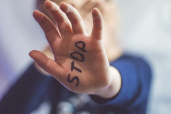 Hand eines Kindes mit den Buchstaben Stop.